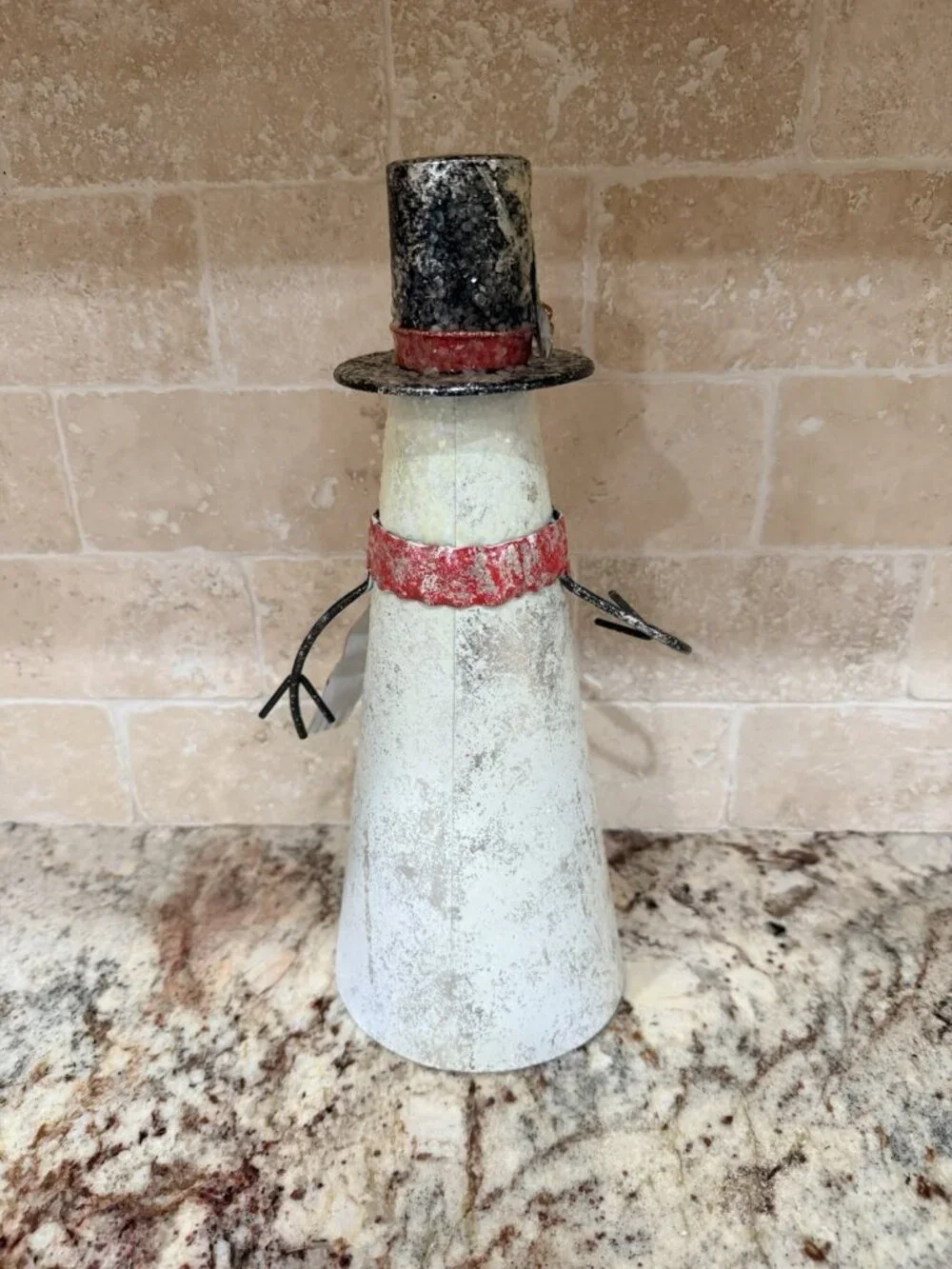Folk-art metal cone snowman top hat, scarf, wire arms, red jingle bell buttons.
